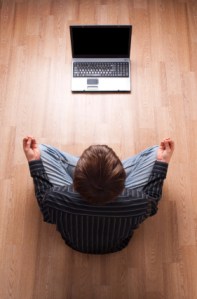 Businessman meditate in front of his laptop